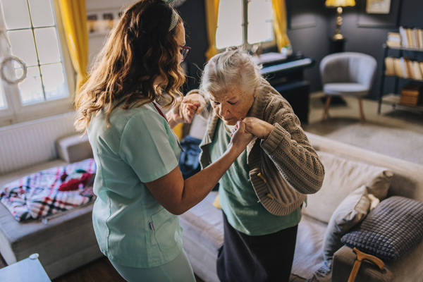 Caregiver assisting elderly woman with mobility and fall prevention care at home in Tampa Area, FL