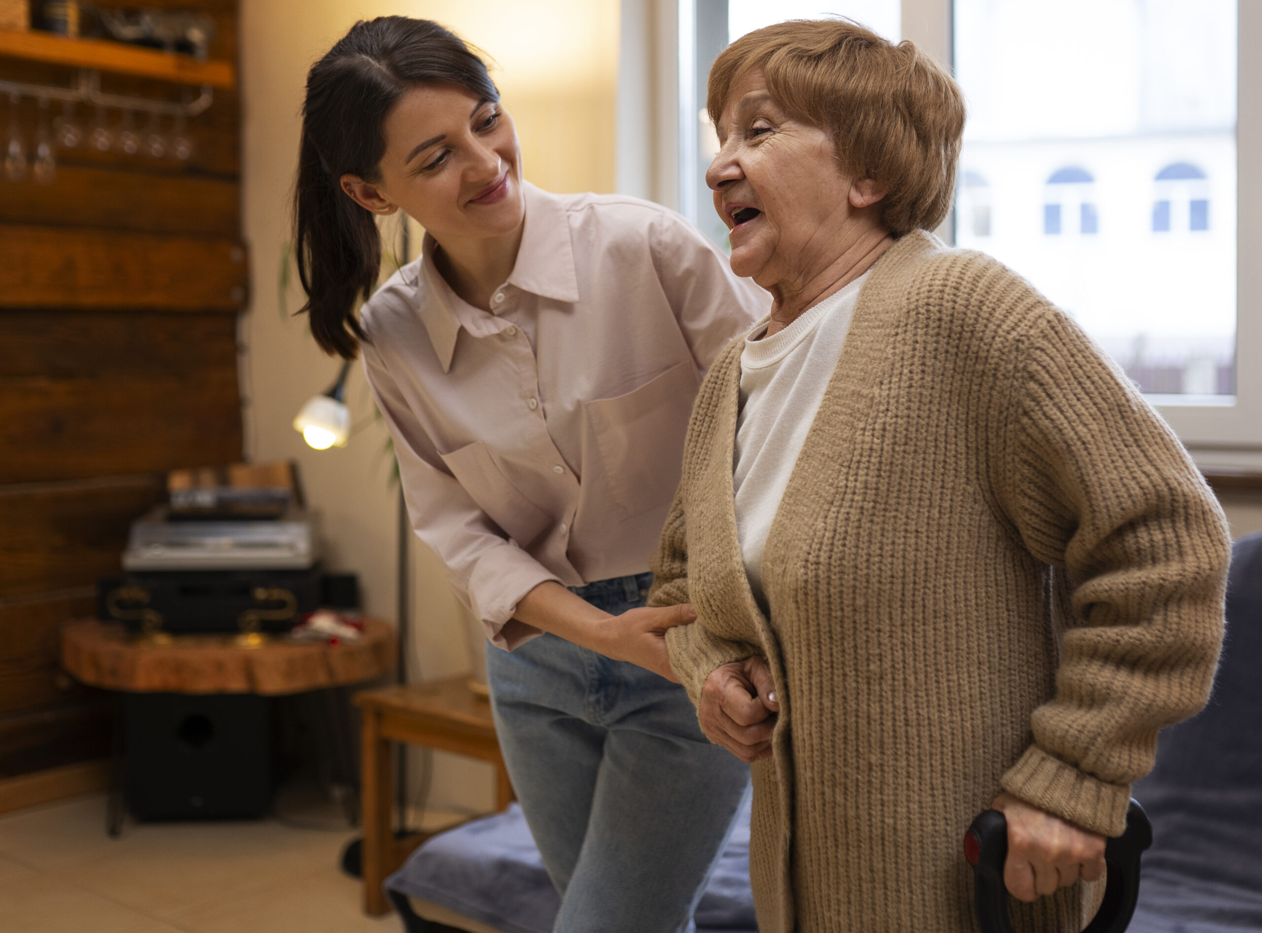 Caregiver helping an elderly woman with walking and mobility support at home in the Tampa Area, FL